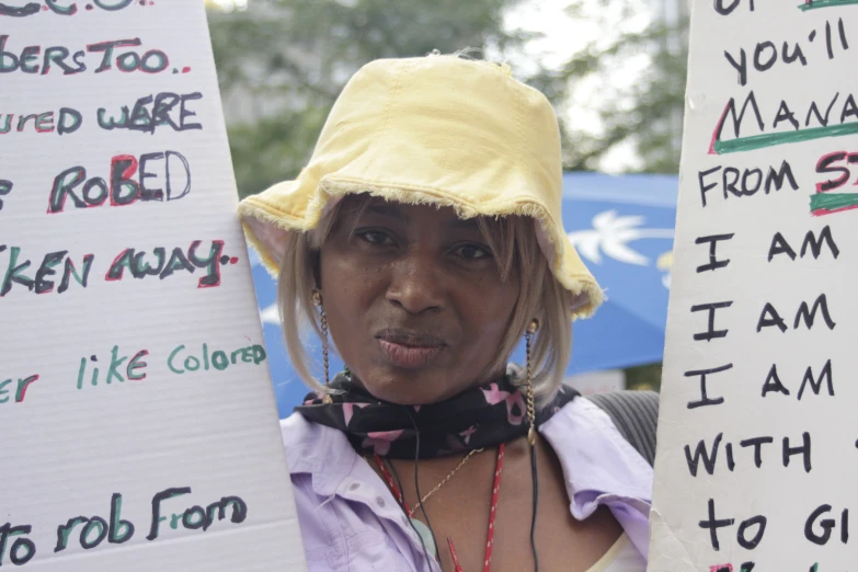 a  with a hat holding signs