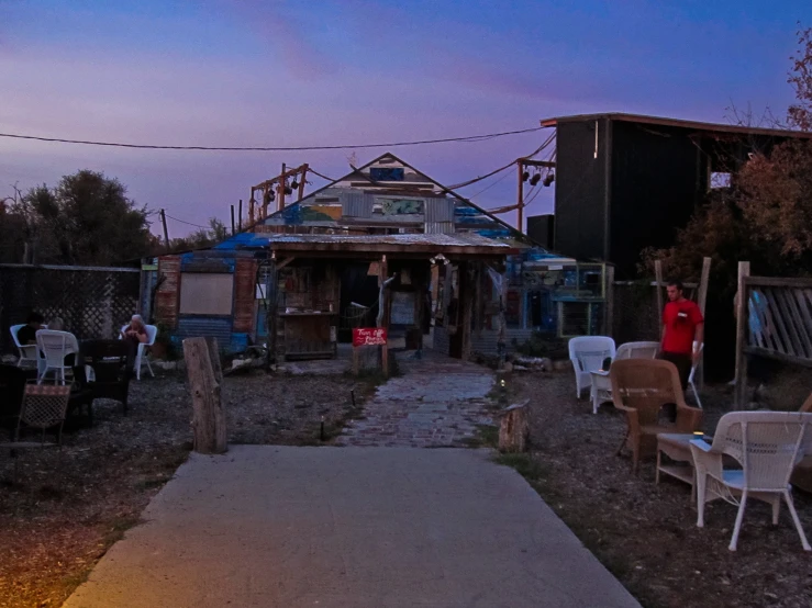 a person standing in the dirt near chairs and other things