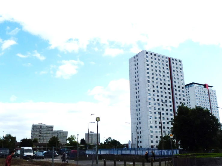 tall buildings in the background with cars parked nearby