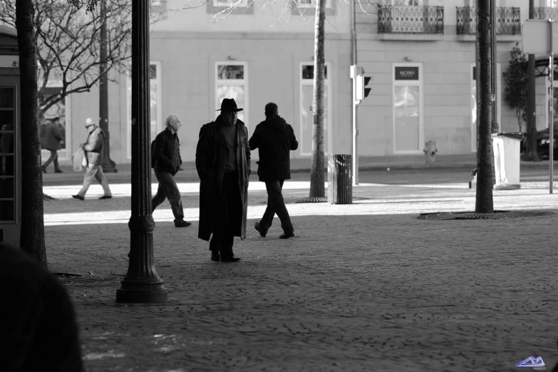 two men walk in the same direction on the sidewalk