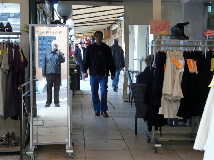 a man is walking inside of a clothing store