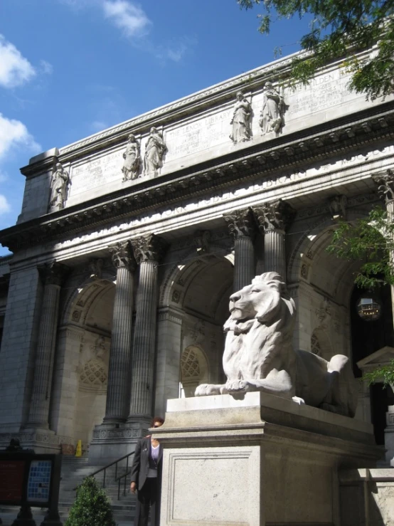 man standing in front of stone lion sculpture on steps