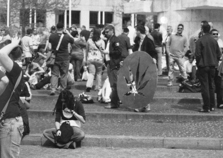 people sitting on some steps looking at some flags