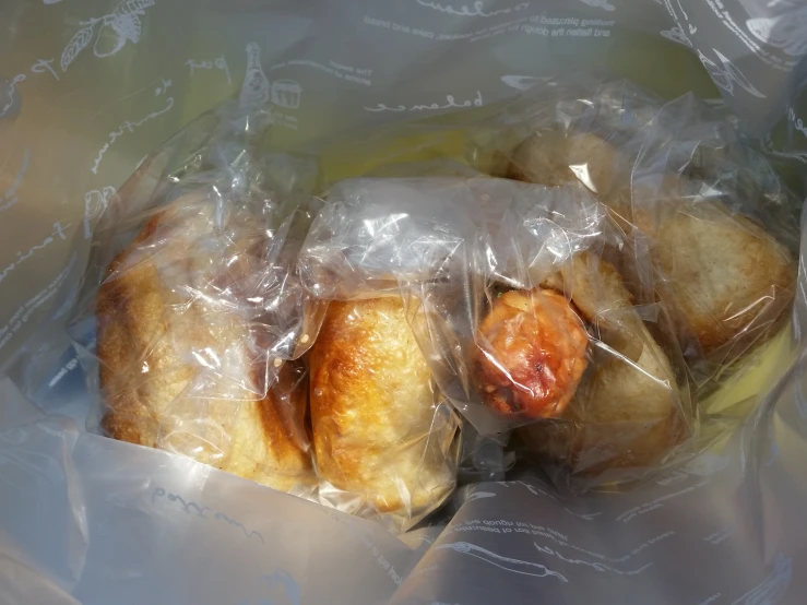 three pieces of bread wrapped in plastic in a bag