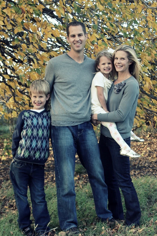 a family poses for a portrait in front of some leaves