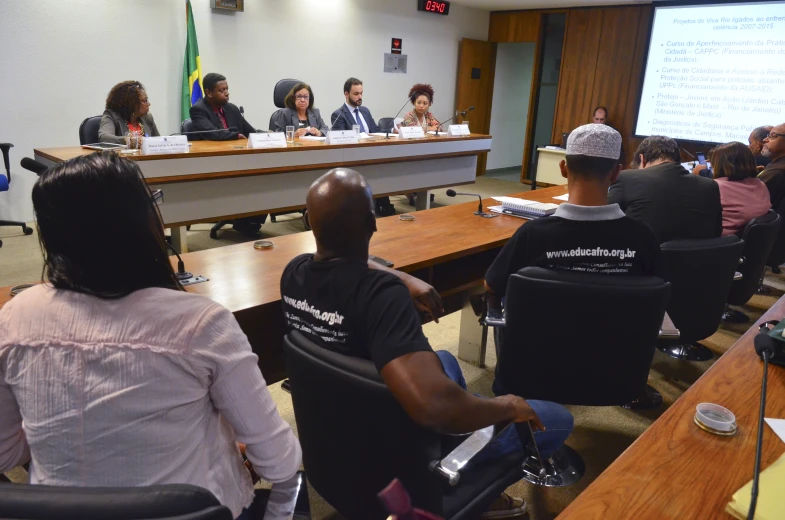 several people sitting in chairs talking and talking