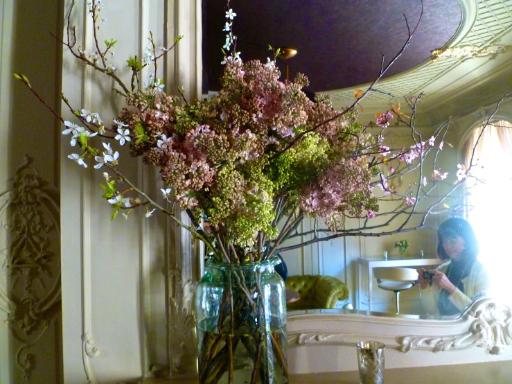 a glass vase with pink flowers on a table in a room