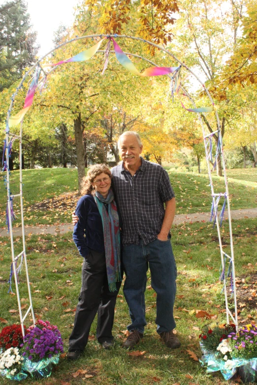 a couple is posing under some colorful decorations