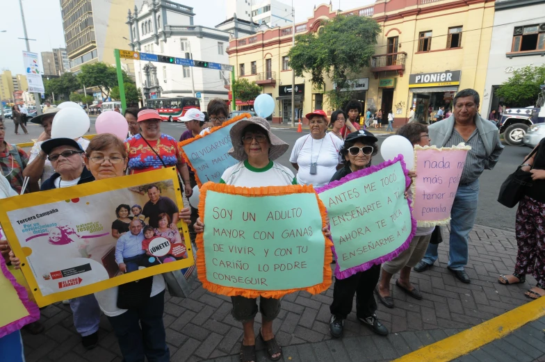 people standing on street holding placares while others hold signs