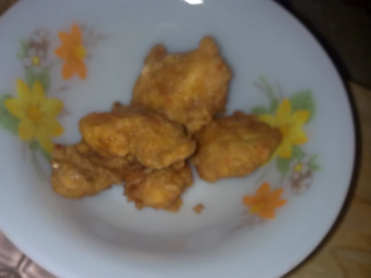 a plate with five fried chicken pieces sitting on it