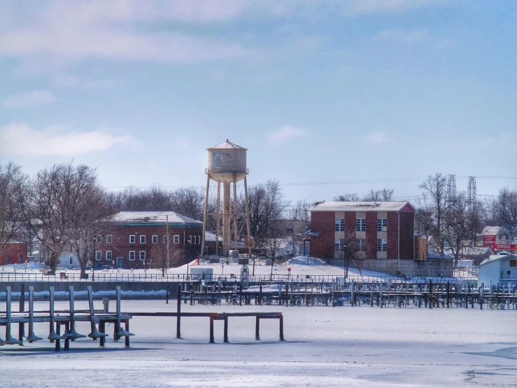 a few benches along a frozen river and a water tower