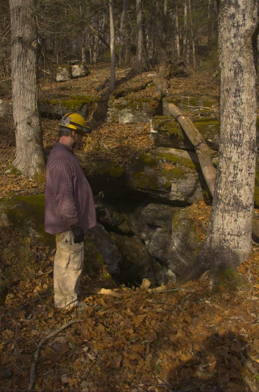 a man is standing next to a pile of leaves