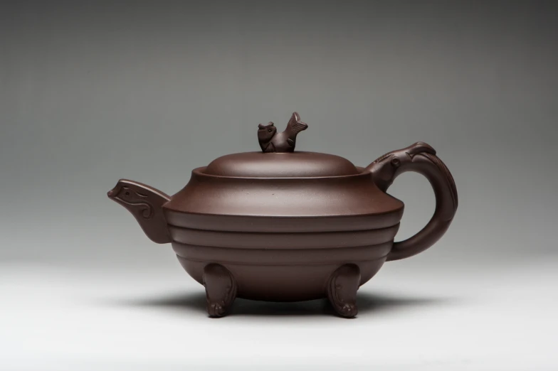 a brown ceramic teapot is shown with a handle