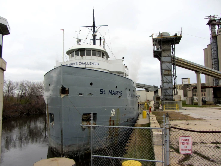 a large gray ship in the water near power towers