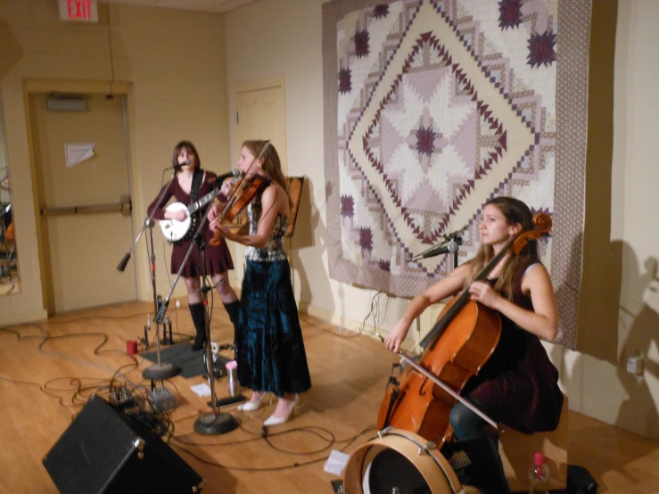 three girls are playing instruments in an open room