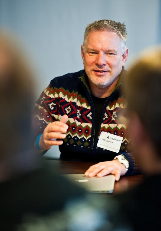 a man talking to people during a meeting