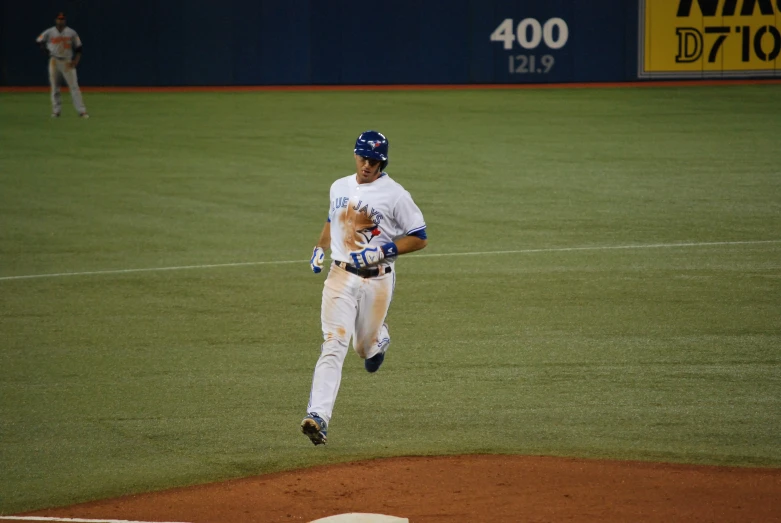a baseball player running down the base on a field