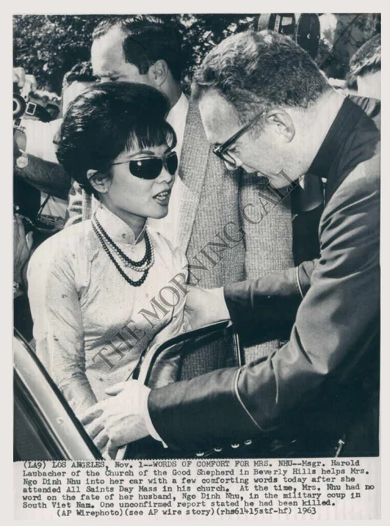 black and white pograph of woman signing an autographed copy