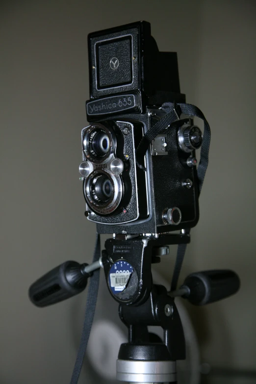 an old fashioned camera is placed on top of a tripod