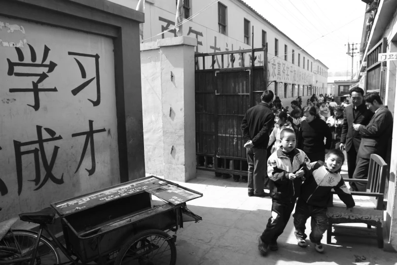 children play on a narrow street in an asian city