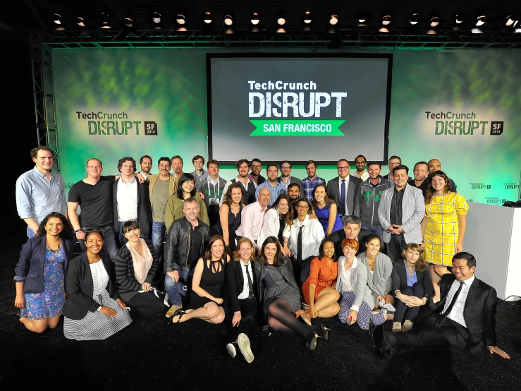 a group of people posing in front of a screen