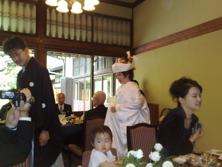 a woman in a hat takes a picture of a woman and a child