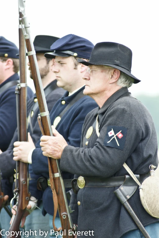 men wearing hats and uniforms holding different items