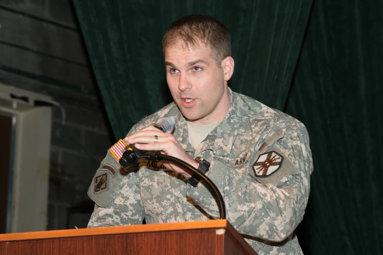 man in military uniform speaking into a microphone