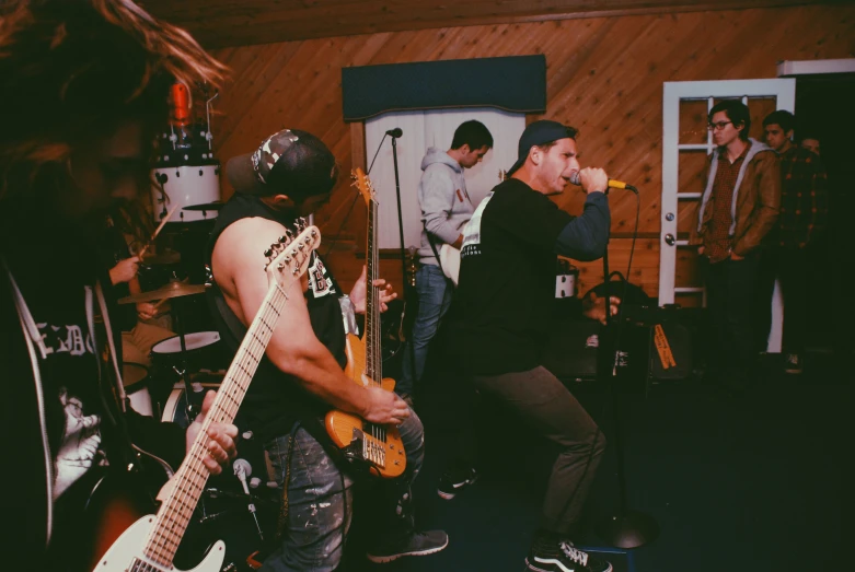 band playing in a small room with wooden walls
