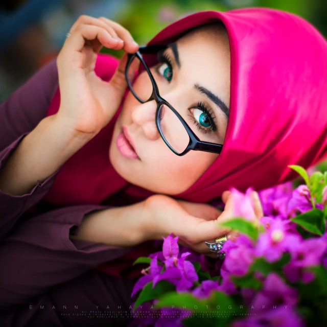 an oriental lady with glasses and a pink hijab