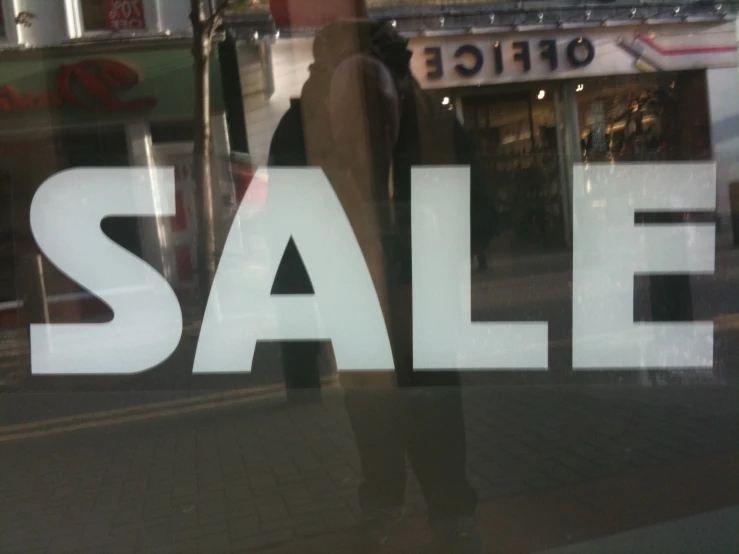 a store front window with the window sale sign displayed
