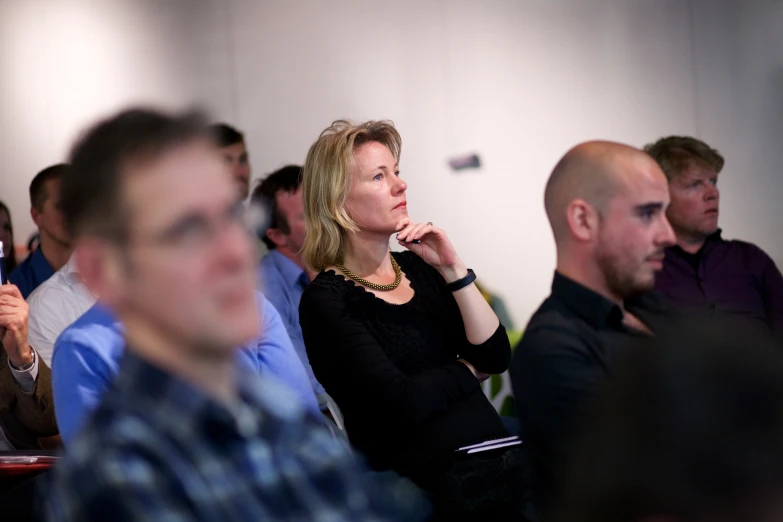 people at a seminar and one is talking on a cellphone