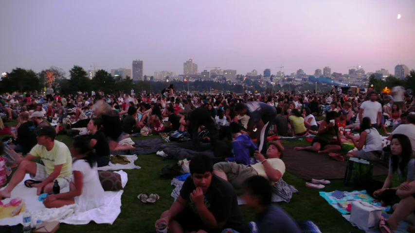 a large crowd of people sitting and standing around each other