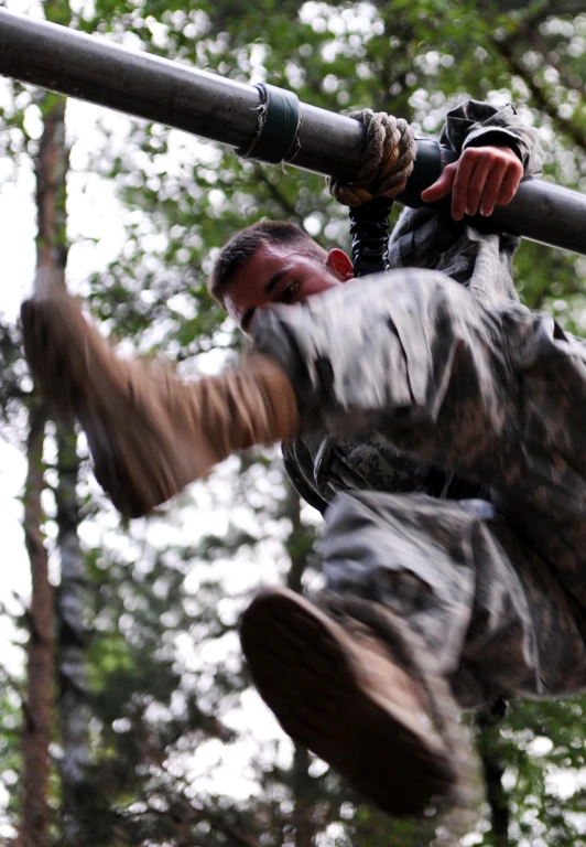 a man climbing on top of a wooden pole