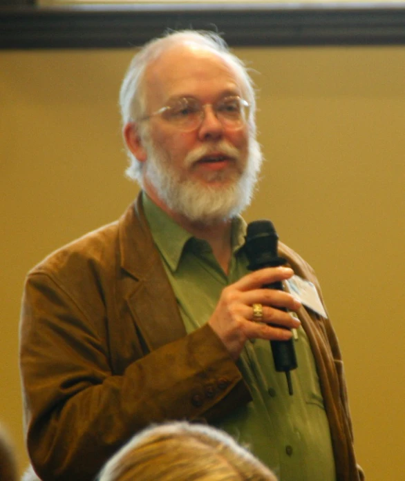 a man with a white beard in a brown jacket