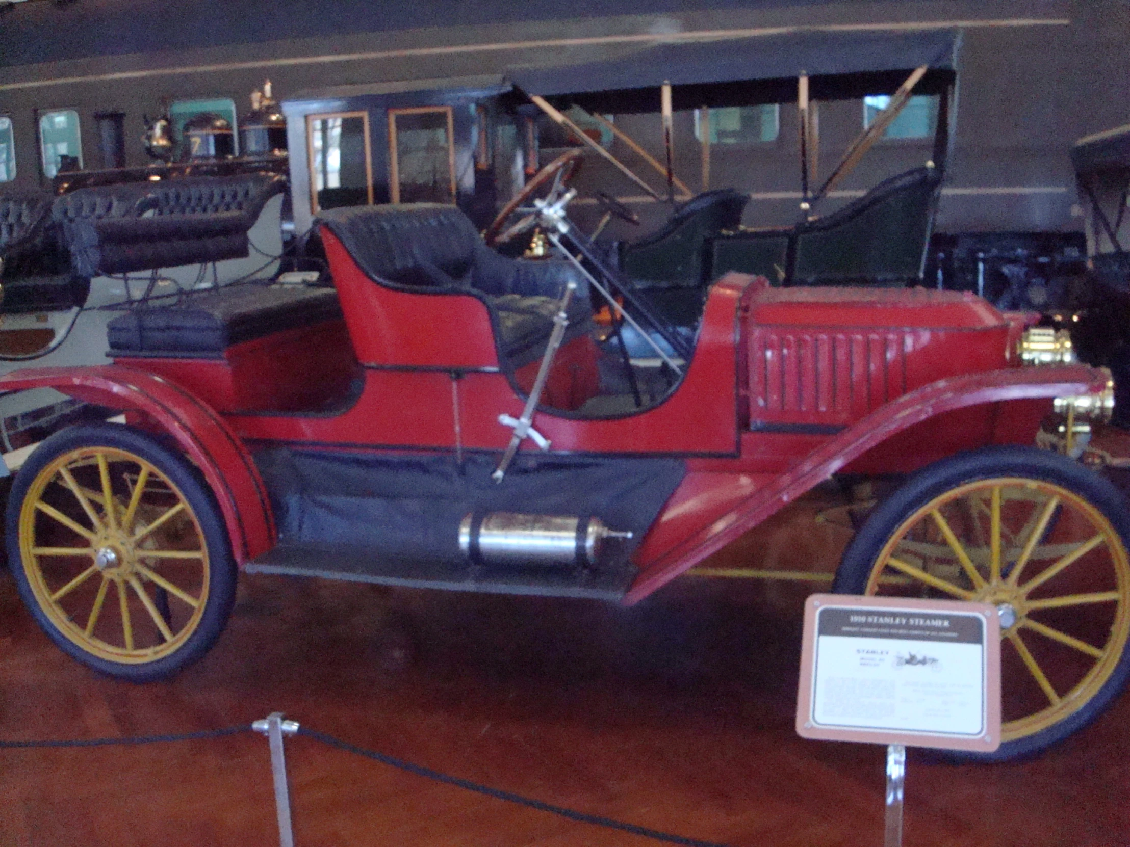 antique cars and other vehicle in a museum