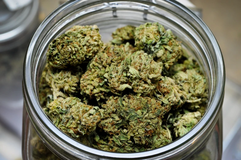 a glass jar filled with lots of marijuana