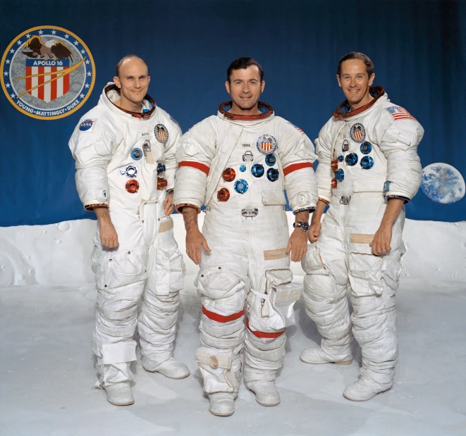 three men dressed in space suits standing on snow