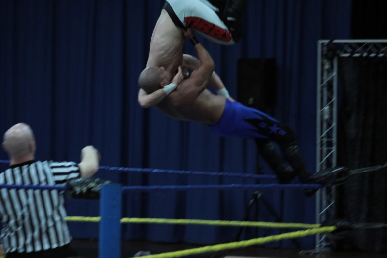 a man is doing a trick in a wrestling ring