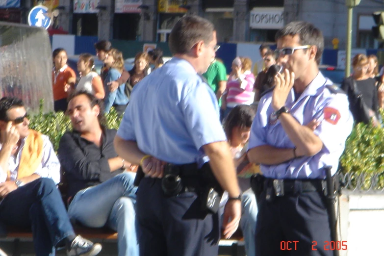 a man holding a small child with his arms around a police officer