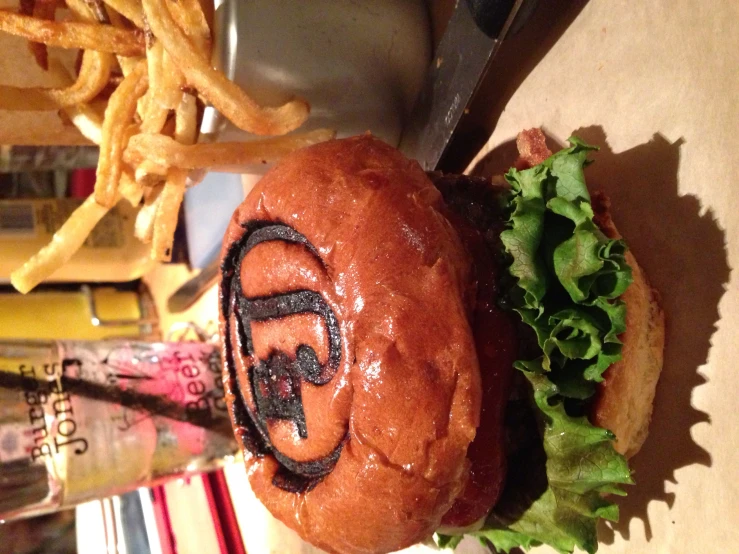 a close up of a sandwich and some fries on a table