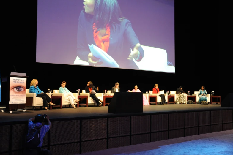 panelists sit on stage at a large conference