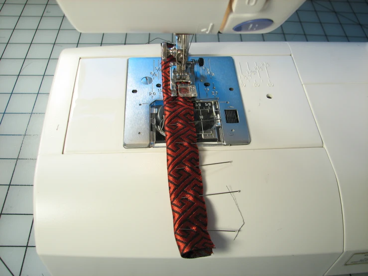 a close up of an sewing machine with a tie on it