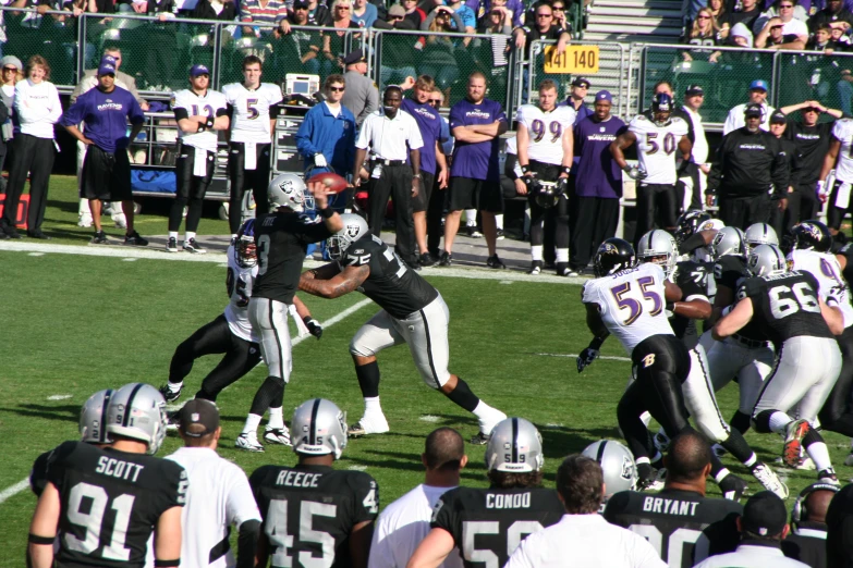 a football player trying to stop a runner from getting out of bounds