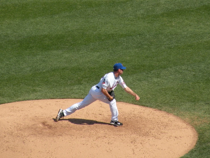 a baseball player pitching a ball on top of a field