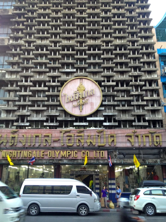 a building with many windows that have a gold sign above it