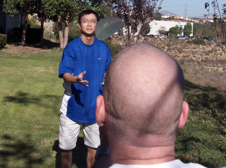 a man with no hair holding soing in his hand