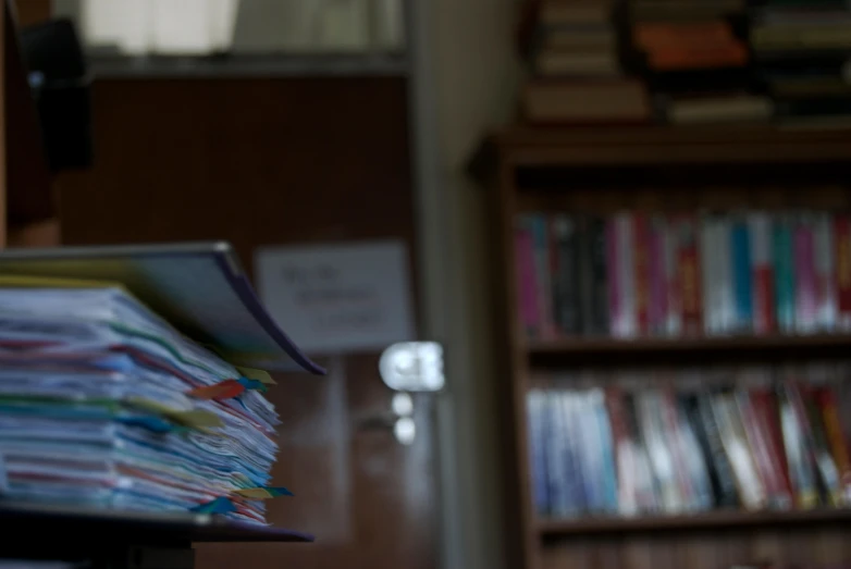 a stack of folders sitting in a room next to shelves