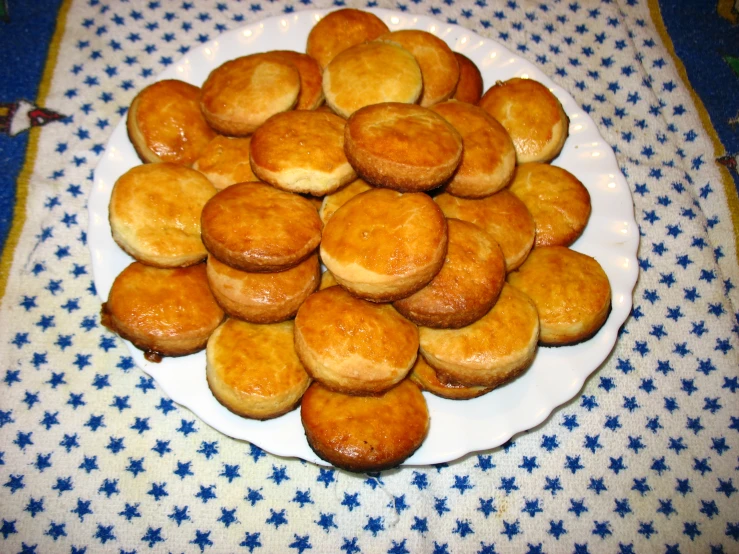 small white plate filled with baked muffins on a blue and white tablecloth