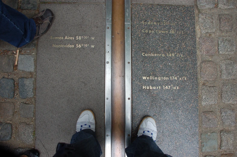 two persons on a sidewalk standing near a metal walkway